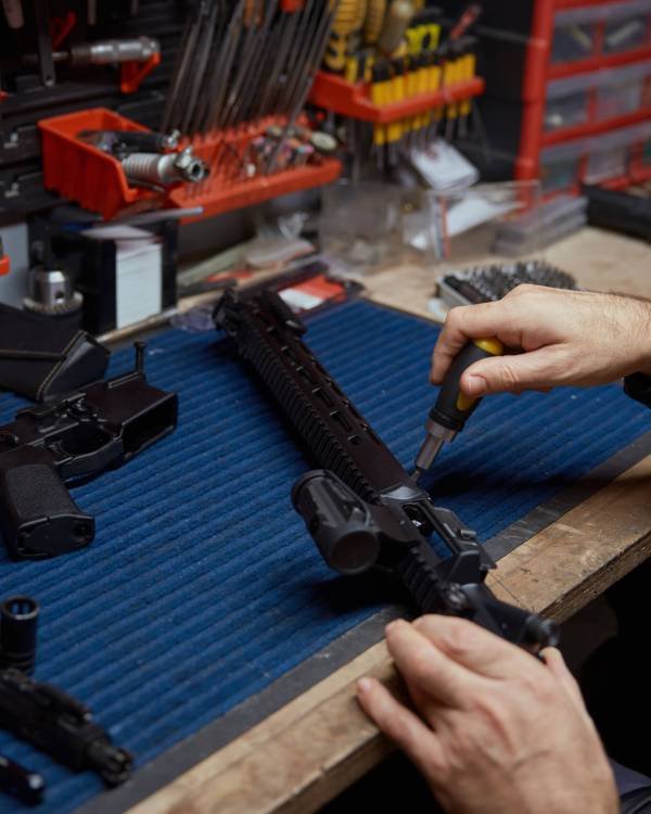 Man putting gun with ammunition in safety case top view closeup. Weapon merchandise at professional shop store